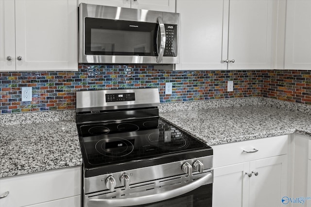 18577 Cottontail Ln, Athens, AL 35613 - kitchen with white cabinetry, appliances with stainless steel finishes, backsplash, and light stone countertops