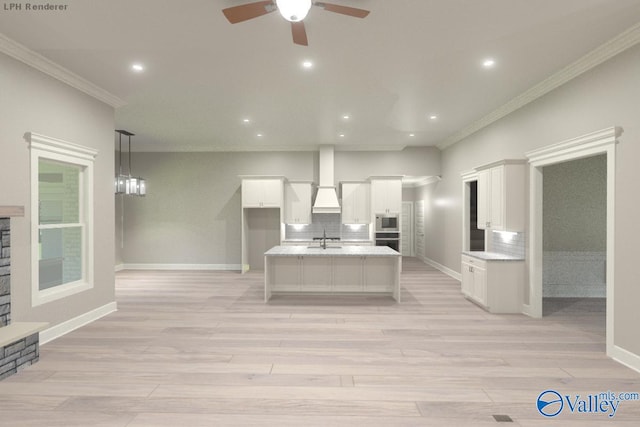 kitchen with white cabinetry, tasteful backsplash, a kitchen island with sink, custom range hood, and light stone countertops