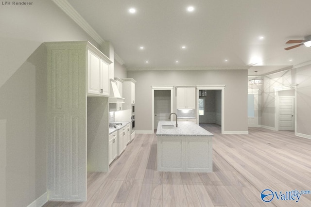 kitchen with white cabinets, ornamental molding, light hardwood / wood-style flooring, light stone counters, and sink