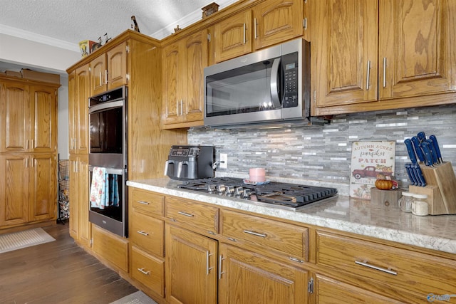 kitchen featuring backsplash, dark hardwood / wood-style flooring, stainless steel appliances, and ornamental molding