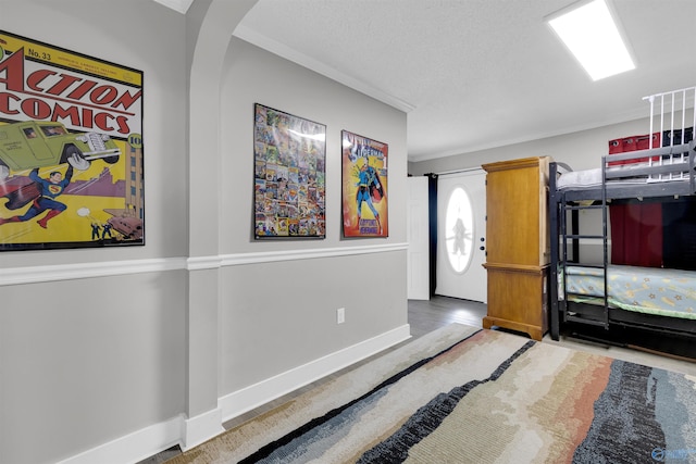 bedroom with a textured ceiling and ornamental molding