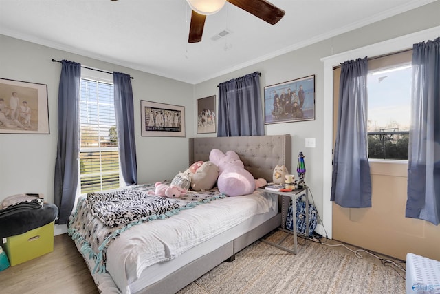 bedroom featuring ceiling fan, light wood-type flooring, and crown molding