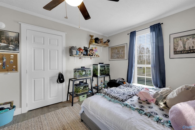 bedroom with hardwood / wood-style floors, a textured ceiling, ceiling fan, and ornamental molding