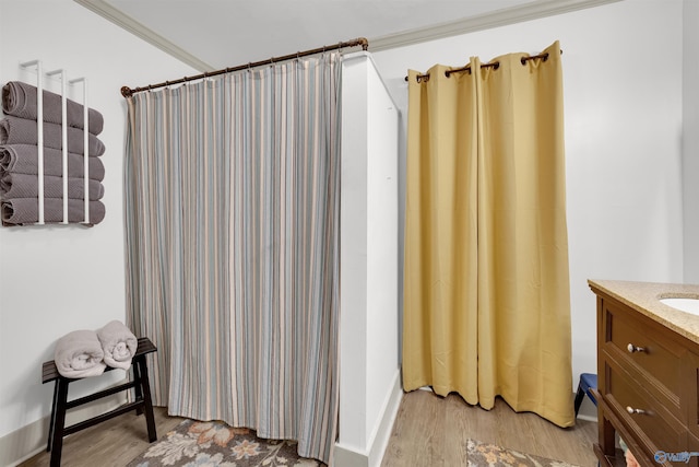 bathroom with wood-type flooring, vanity, walk in shower, and crown molding