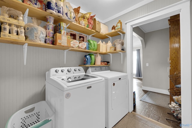 laundry room with washer and dryer, light hardwood / wood-style floors, crown molding, and wooden walls