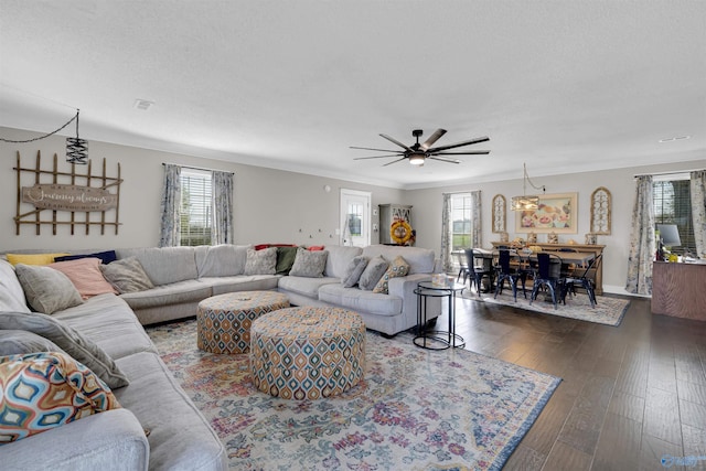 living room with dark hardwood / wood-style floors, a healthy amount of sunlight, ornamental molding, and ceiling fan