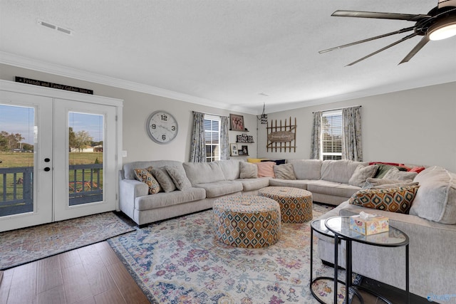 living room featuring ceiling fan, french doors, dark hardwood / wood-style floors, a textured ceiling, and ornamental molding