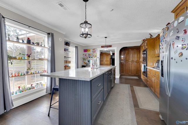 kitchen featuring plenty of natural light, gray cabinets, stainless steel fridge with ice dispenser, and an island with sink