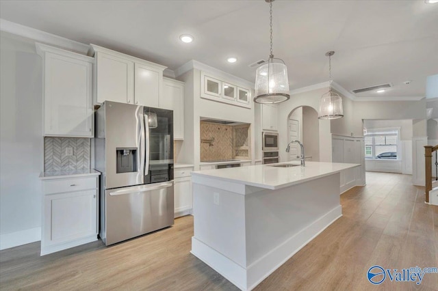 kitchen with light wood finished floors, light countertops, white cabinetry, and stainless steel appliances
