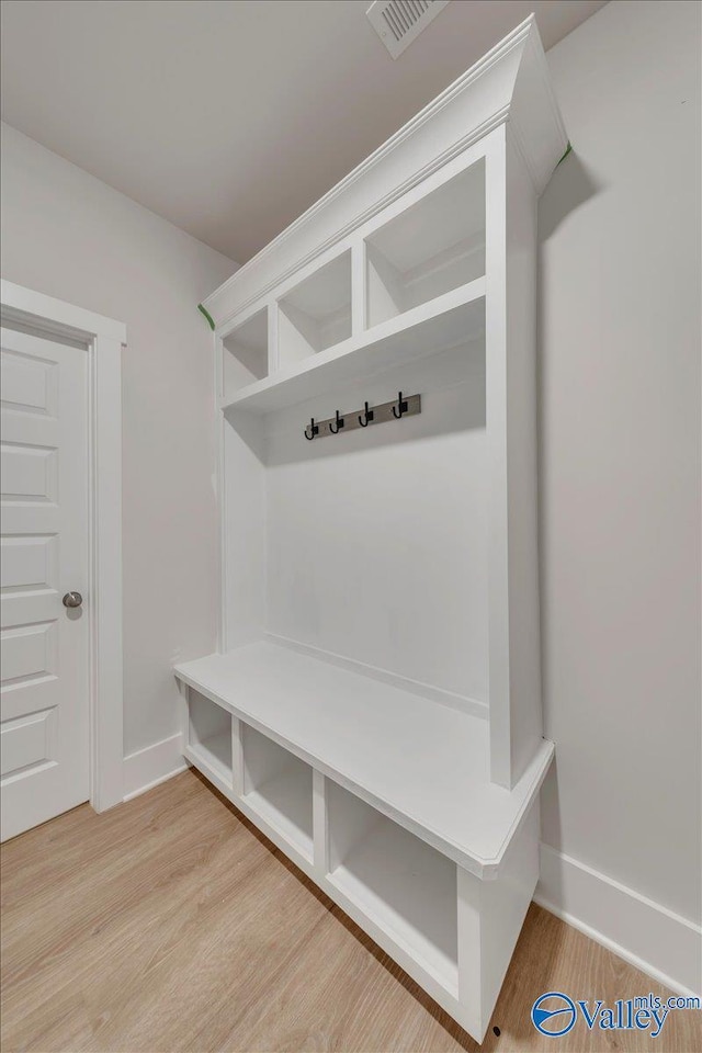 mudroom featuring visible vents, baseboards, and wood finished floors