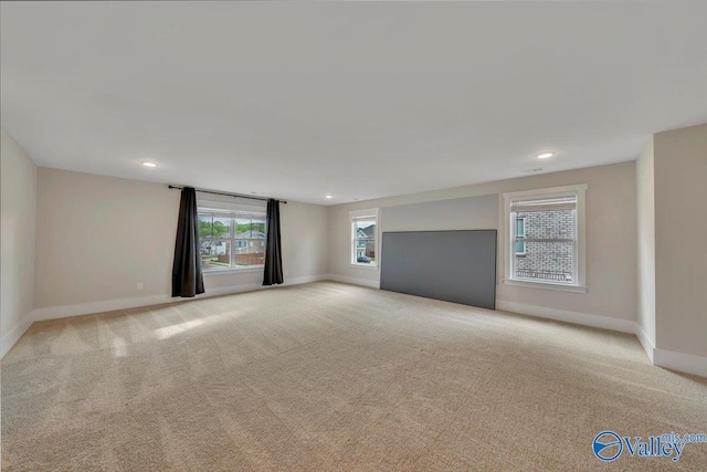 unfurnished living room with baseboards, recessed lighting, and carpet