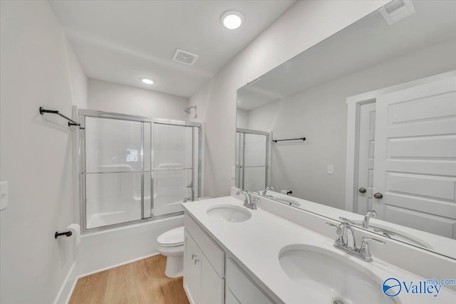 full bath featuring a sink, visible vents, toilet, and wood finished floors