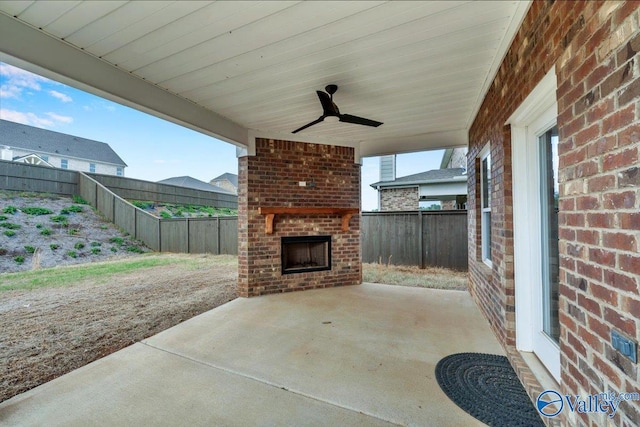 view of patio / terrace with a fenced backyard, ceiling fan, and an outdoor brick fireplace