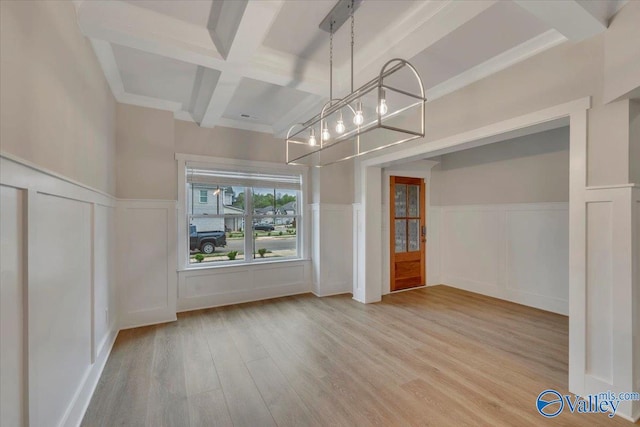unfurnished dining area featuring a chandelier, beam ceiling, wood finished floors, a wainscoted wall, and coffered ceiling