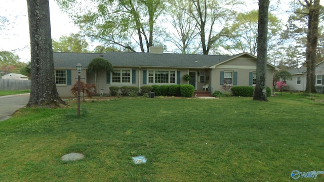 ranch-style home with a chimney and a front yard