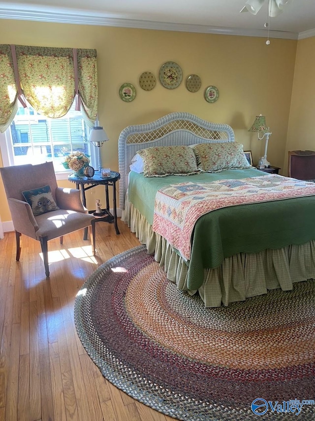 bedroom with ornamental molding and hardwood / wood-style flooring