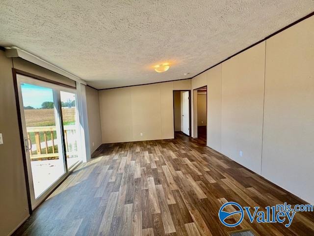 unfurnished room featuring a textured ceiling and dark hardwood / wood-style floors