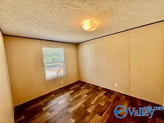 interior space featuring a textured ceiling and dark hardwood / wood-style flooring