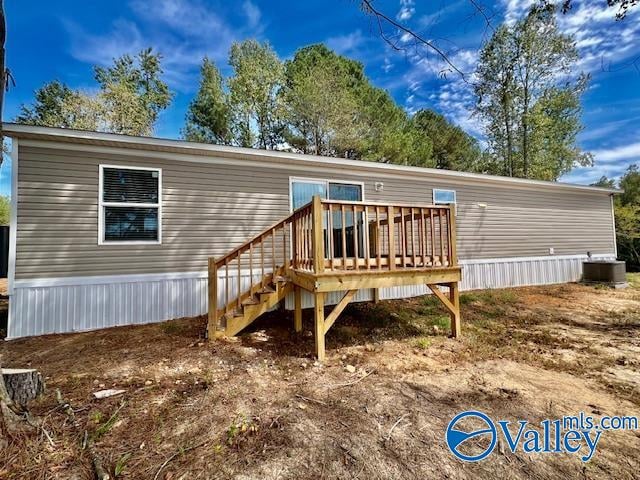 rear view of property with a wooden deck and central air condition unit