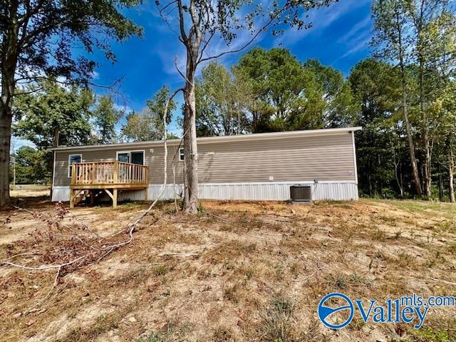 back of house featuring cooling unit and a wooden deck