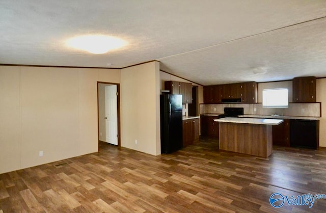 kitchen featuring ornamental molding, black appliances, dark hardwood / wood-style flooring, and a kitchen island