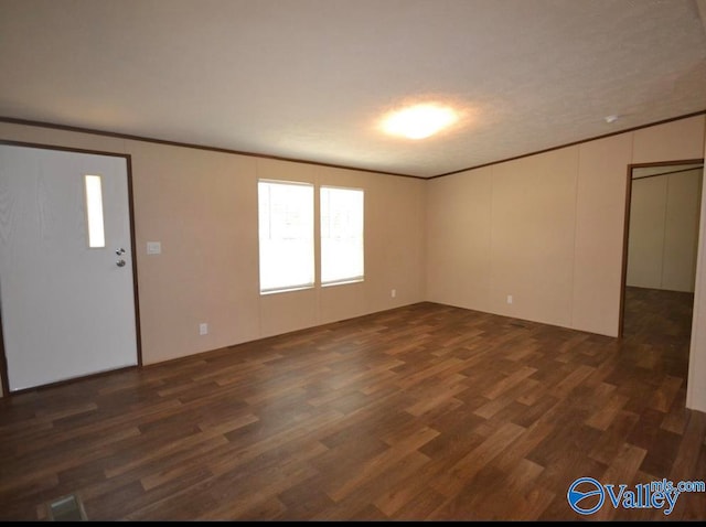 spare room with dark wood-type flooring and a textured ceiling