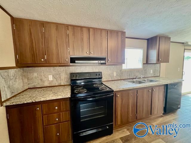 kitchen featuring black appliances, decorative backsplash, a textured ceiling, and sink