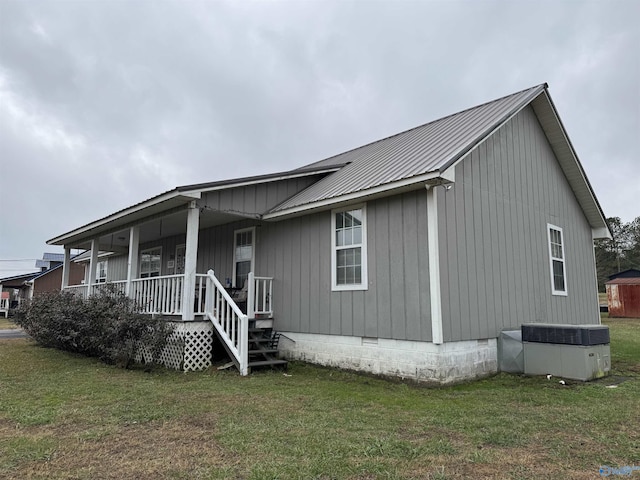 exterior space with central AC unit, covered porch, and a front yard