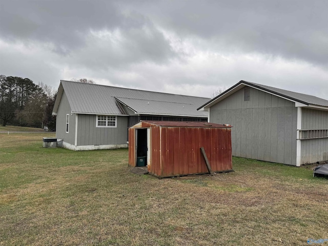 back of property featuring a yard and an outdoor structure