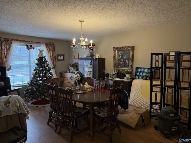 dining space featuring a textured ceiling, a notable chandelier, and hardwood / wood-style flooring