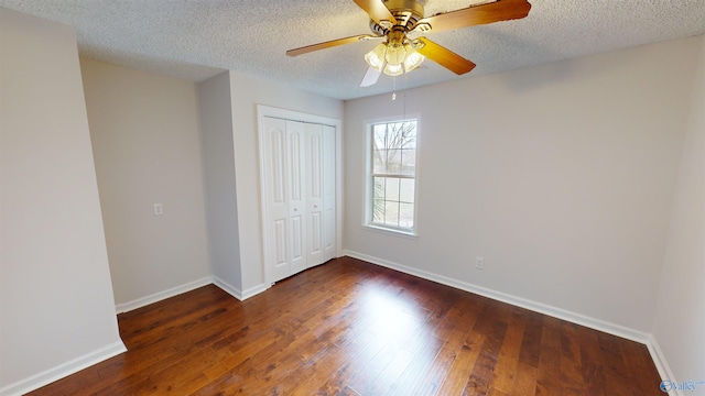 unfurnished bedroom featuring ceiling fan, dark wood-type flooring, a closet, and a textured ceiling