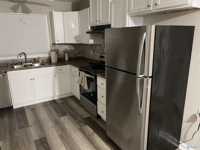 4503 Kenwood Dr, Huntsville, AL 35810 - kitchen with dark countertops, a sink, appliances with stainless steel finishes, white cabinetry, and under cabinet range hood
