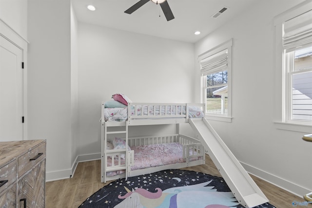 bedroom with baseboards, visible vents, and light wood finished floors