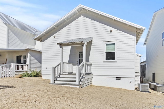 view of front facade with crawl space, metal roof, a front lawn, and central AC unit