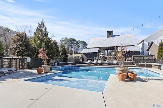 view of swimming pool with a patio area, fence, and a fenced in pool