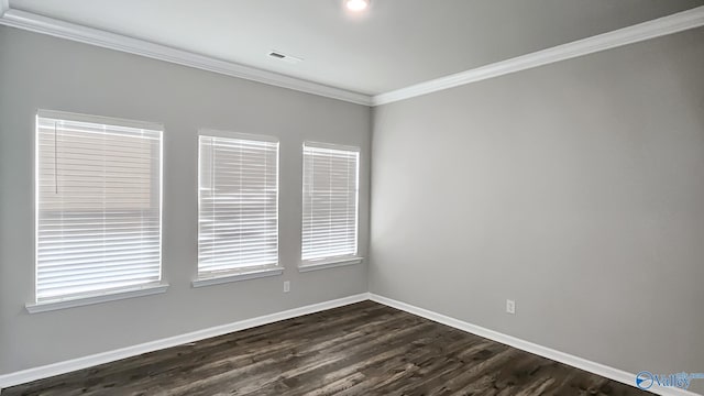 spare room featuring dark hardwood / wood-style flooring and crown molding