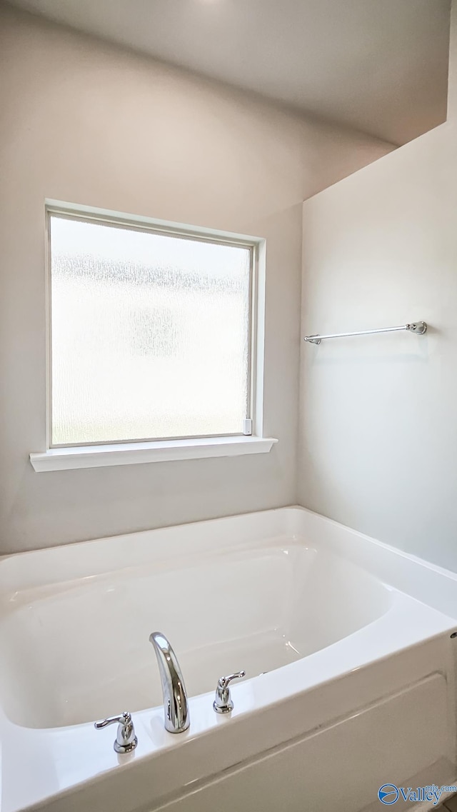 bathroom featuring a bath and a wealth of natural light