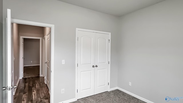 unfurnished bedroom with dark hardwood / wood-style floors and a closet