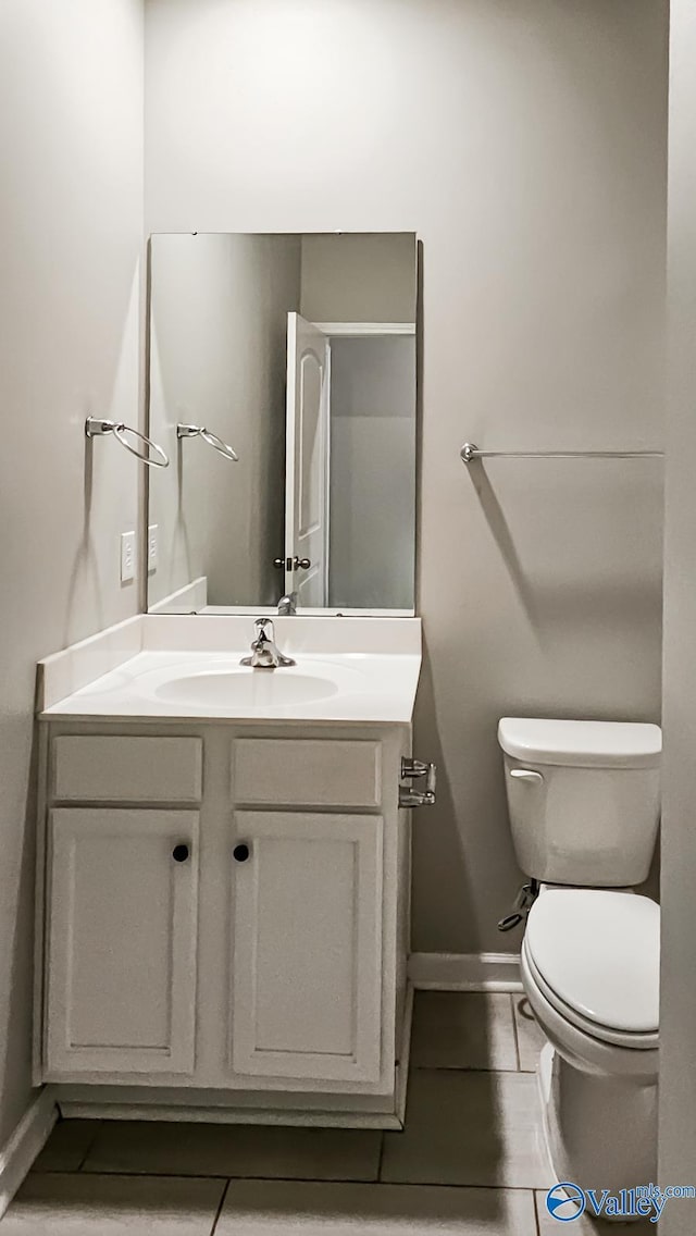 bathroom featuring tile patterned flooring, vanity, and toilet