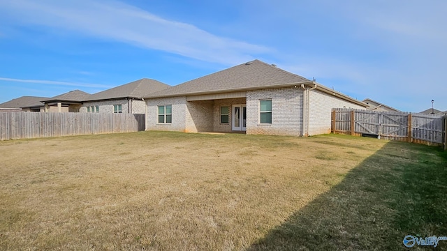 rear view of property featuring a lawn