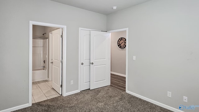 unfurnished bedroom featuring ensuite bathroom and light colored carpet