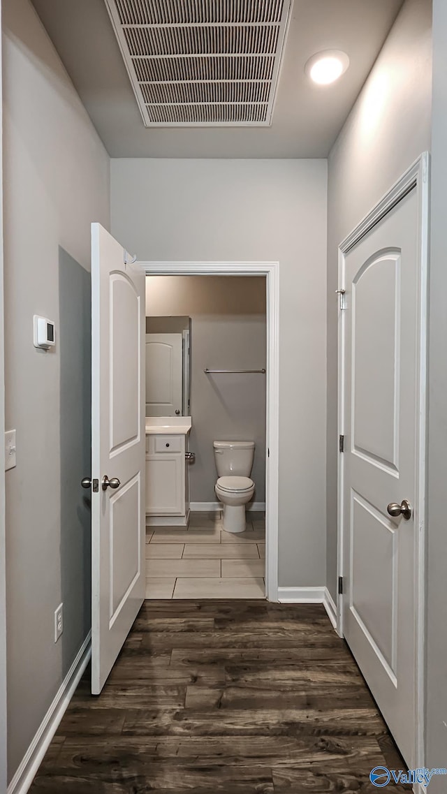 bathroom with toilet, vanity, and hardwood / wood-style flooring