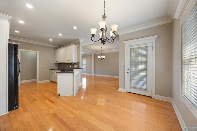 22222 Merlot Dr, Athens, AL 35613 - kitchen with dark countertops, a chandelier, plenty of natural light, and crown molding