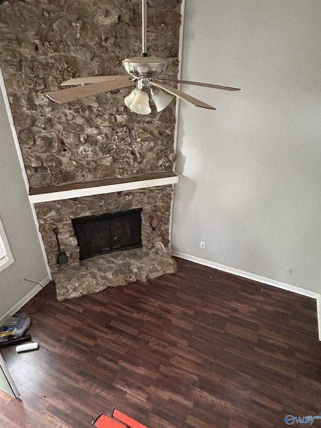 unfurnished living room featuring a ceiling fan, baseboards, a fireplace, and wood finished floors