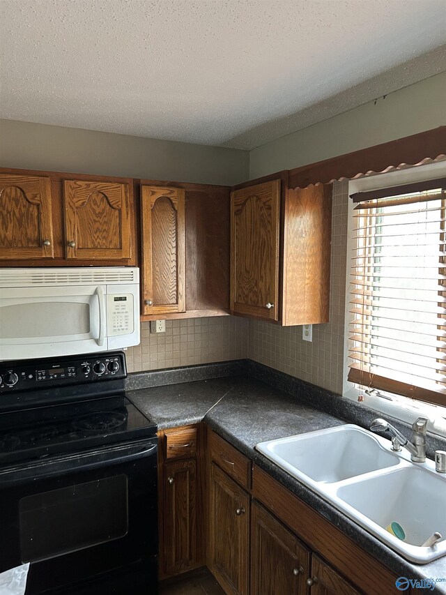 kitchen featuring black / electric stove, white microwave, a sink, dark countertops, and tasteful backsplash