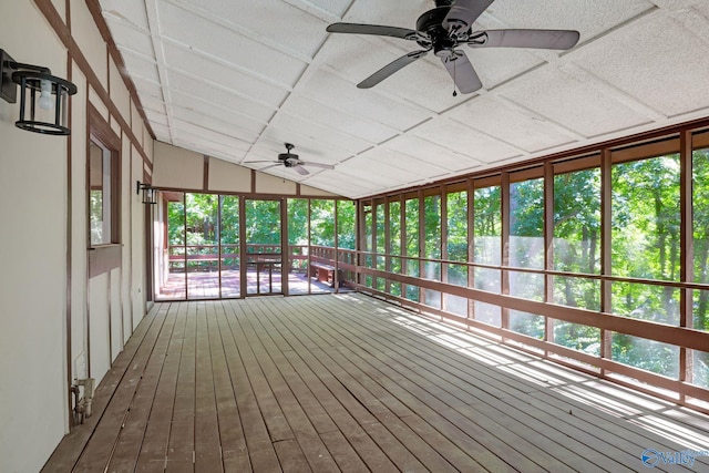 unfurnished sunroom with a ceiling fan and vaulted ceiling