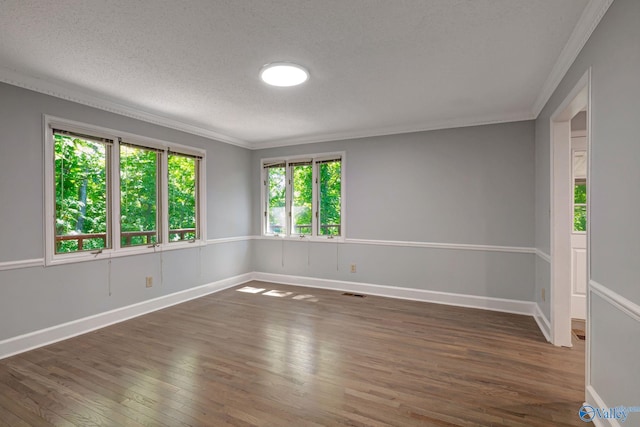 empty room featuring crown molding, baseboards, wood-type flooring, and a textured ceiling