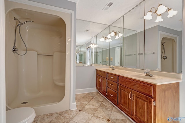 bathroom featuring double vanity, visible vents, a stall shower, and a sink