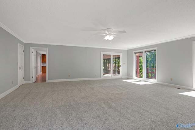 carpeted spare room with baseboards, a textured ceiling, and crown molding