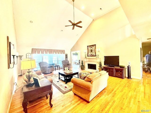 living room with ceiling fan, hardwood / wood-style flooring, and high vaulted ceiling